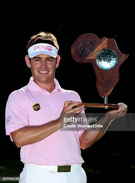 Louis Oosthuizen of South Africa poses with the trophy after winning the Africa Open after a three way play-off against Chris Wood of England and...