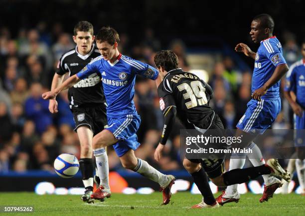 Josh McEachran of Chelsea runs with the ball under pressure from Mark Kennedy of Ipswich Town during the FA Cup sponsored by E.O.N 3rd Round match...