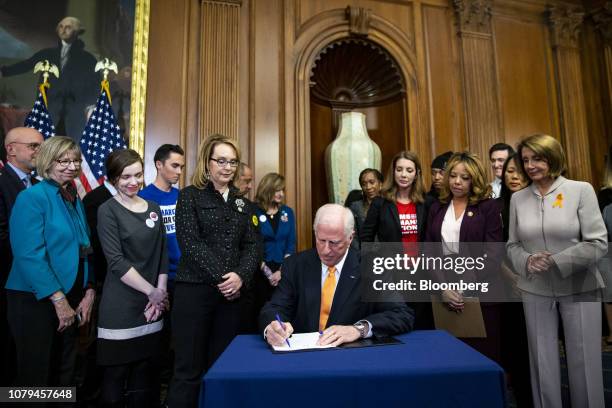 Representative Mike Thompson, a Democrat from California, center, signs a bill as Gabrielle "Gabby" Giffords, former U.S. Representative from...