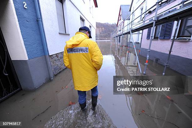 Man has written "Flood Aid" on his cagoule as he walks through a flooded street in the western German town of Koblenz, where the rivers Mosel and...