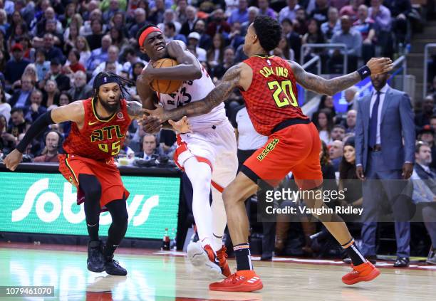 Pascal Siakam of the Toronto Raptors dribbles the ball as DeAndre' Bembry and John Collins of the Atlanta Hawks defend during the second half of an...