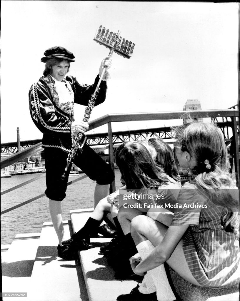 Actor John Curry of Dee Why dressed as Sir Walter Raleigh in the John Curry Folk review at the Sydney Opera House, plays the Lagerphone, a totally Australian musical instrument made of bottle tops to a group of children from the South Strathfield Public S