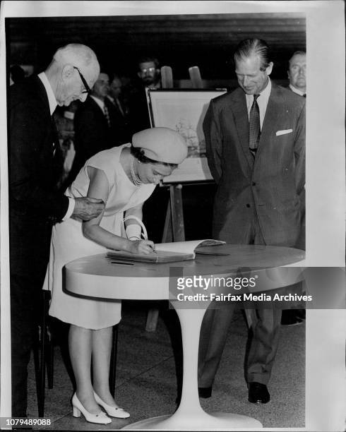 Queen Elizabeth signing the visitors book.At left Sir Philip Baxter. . October 20, 1973. .