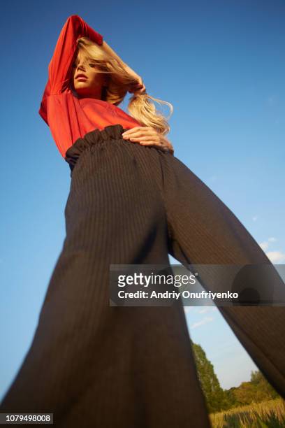 portrait of beautiful young woman dancing in a meadow - fashion model stock-fotos und bilder