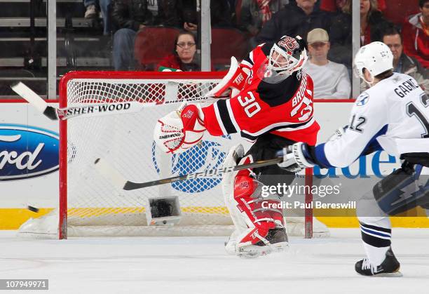 Martin Brodeur of the New Jersey Devils clears the puck from in front of Simon Gagne of the Tampa Bay Lightning in the second period of an NHL hockey...