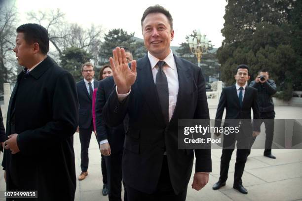 Tesla CEO Elon Musk, center, waves as he waits for a meeting with Chinese Premier Li Keqiang at the Zhongnanhai leadership compound on January 9,...