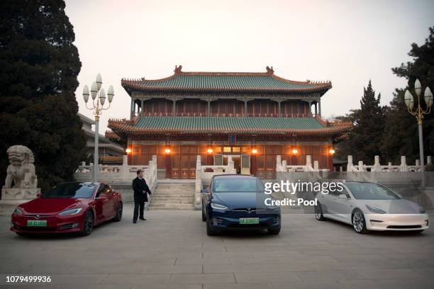 Tesla vehicles are parked outside of a building at the Zhongnanhai leadership compound during a meeting between Tesla CEO Elon Musk and Chinese...