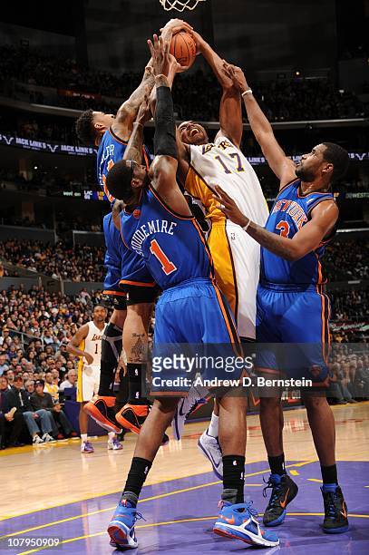 Andrew Bynum of the Los Angeles Lakers is challenged by Wilson Chandler, Amar'e Stoudemire, and Shawne Williams of the New York Knicks on his way to...
