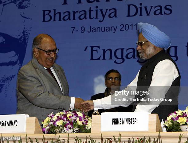 Manmohan Singh and Sir Anand Satyanand shake hands during the inaugural session of the 9th Pravasi Bharatiya Divas 2011 at Vigyan Bhavan in New Delhi...