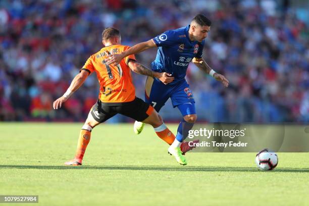 Dimitri Petratos of the Jets competes for the ball with Eric Bautheac of the Roar during the round seven A-League match between the Newcastle Jets...