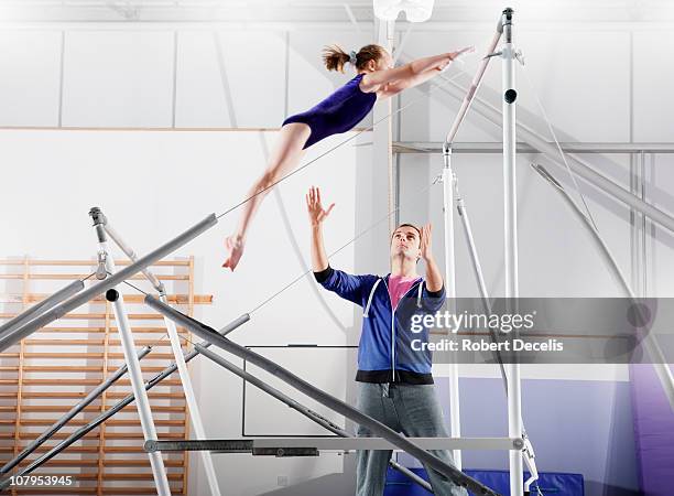 trainer guiding  young gymnast on parallel bars - bar stock pictures, royalty-free photos & images