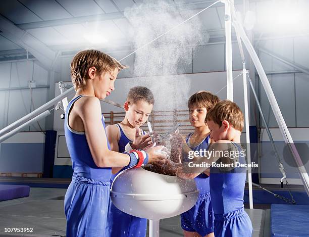 young male gymnasts chalking hands - human age stock pictures, royalty-free photos & images