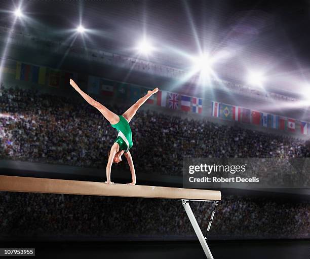 female gymnast competing on balance beam - gymnastics imagens e fotografias de stock