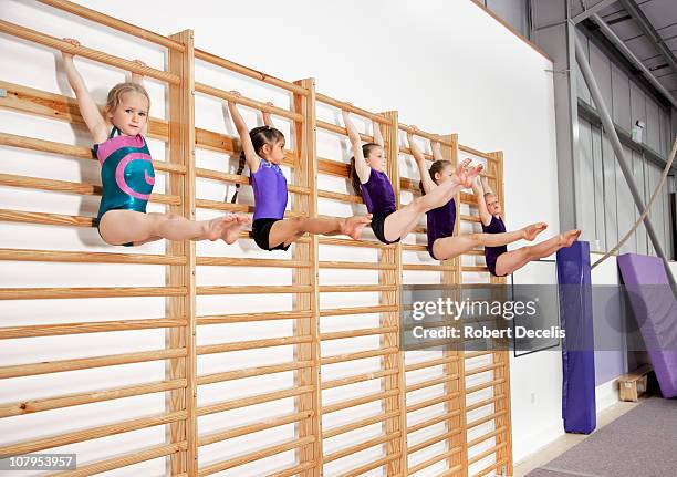 five young gymnasts holding pose on bars - gymnastics bar stock pictures, royalty-free photos & images