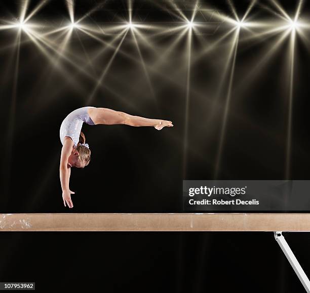 young female gymnast on balance beam - gymnastics stock pictures, royalty-free photos & images