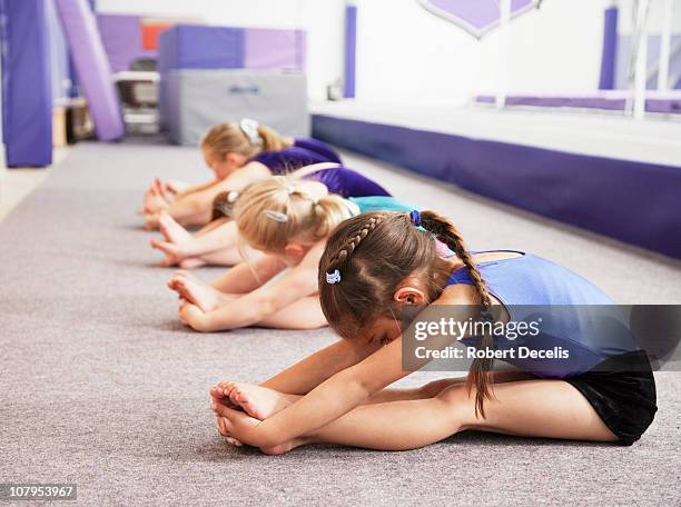 young gymnasts performing warming up routine - athlete training stockfoto's en -beelden