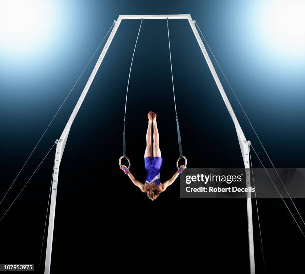 male gymnast upside down performing on rings - athlete stock pictures, royalty-free photos & images