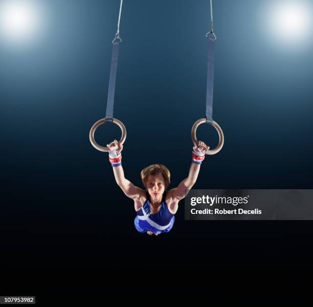 male gymnast performing on rings - acrobat stock pictures, royalty-free photos & images