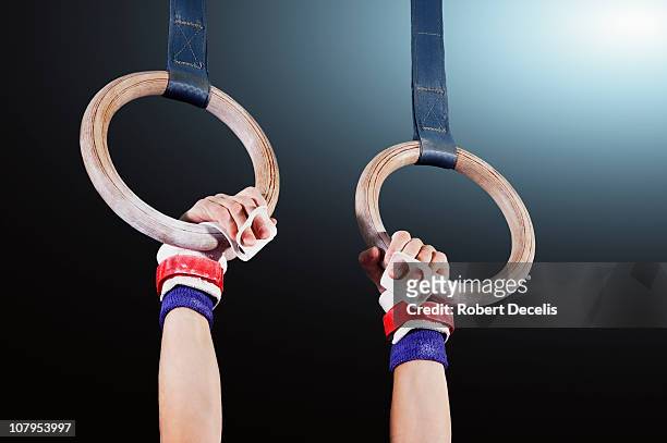 young gymnast hanging from rings - gymnastiek stockfoto's en -beelden