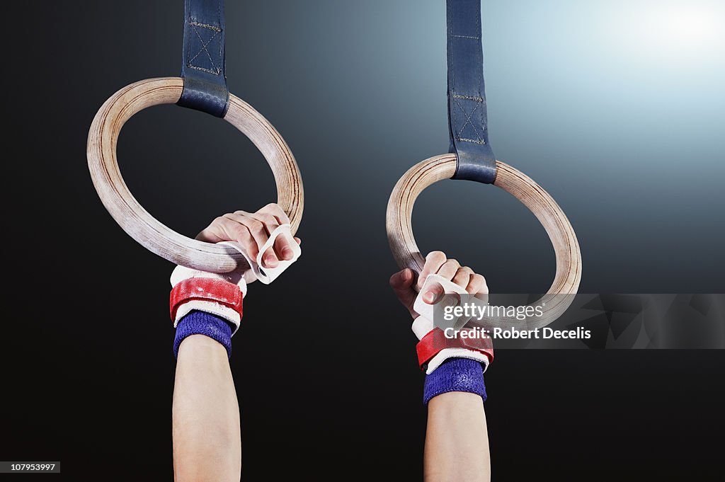 Young gymnast hanging from rings