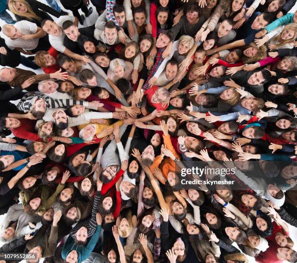 above view of crowd of people joining hands in unity. - solidariedade imagens e fotografias de stock