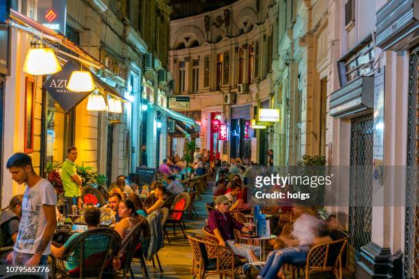 cafes within the pasajul macca- vilacrosse arcade at night in bucharest, romania, europe - bucharest stock pictures, royalty-free photos & images