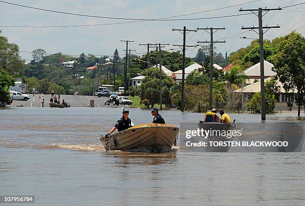 Police use a boat to patrol the streets for looters after the Fitzroy River broke its banks and inundated much of Rockhampton on January 4, 2011. Up...