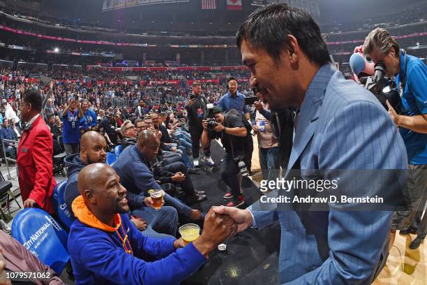Professional Boxers Floyd Mayweather and Manny Pacquiao greet each other during the game between the Charlotte Hornets and LA Clippers on January 8,...