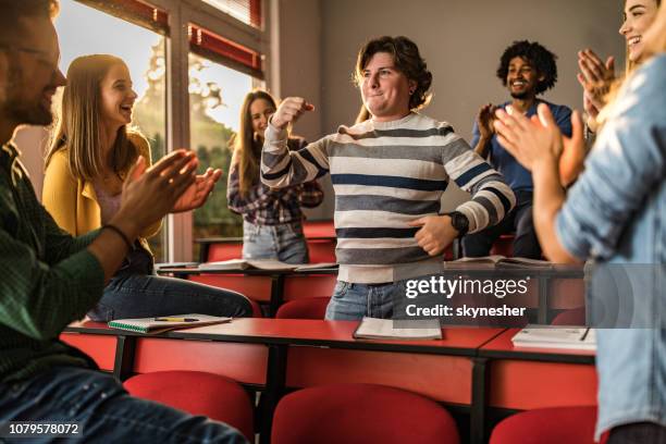 junge studenten applaudieren ihre freundin im klassenzimmer. - selbstverliebt stock-fotos und bilder