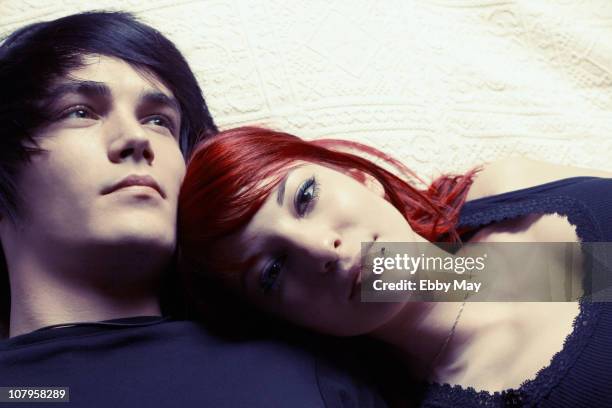 portrait of young couple lying on bed - the who may 21 2010 stock pictures, royalty-free photos & images