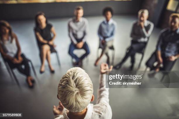 above view of female instructor leading a business group therapy. - education concept stock pictures, royalty-free photos & images