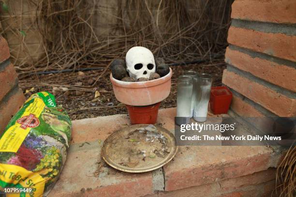 Miniature altar with a replica of a human skull sits inside a camouflage tent in the backyard of the home of Jared Lee Loughner January 9, 2011 in...