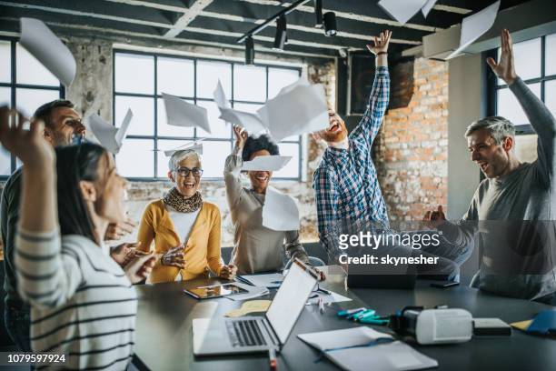 cheerful business team throwing papers up in the air at office. - throwing stock pictures, royalty-free photos & images
