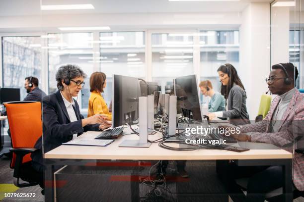 lavoratori del call center - persona in secondo piano foto e immagini stock
