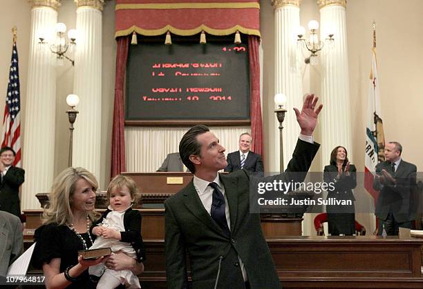 California Lt. Governor Gavin Newsom wavesd as his wife Jennifer Siebel-Newsom and daughter Montana look on before he was sworn in as the 49th Lt....