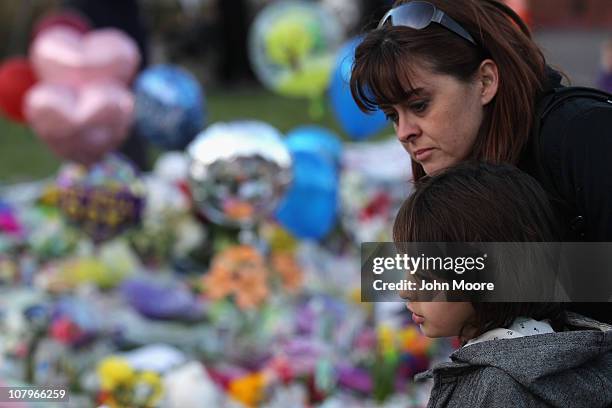 Kristi Thomas and her daughter Tayler visit a memorial shrine to victims of the Saturday shooting rampage, at University Medical Center on January...