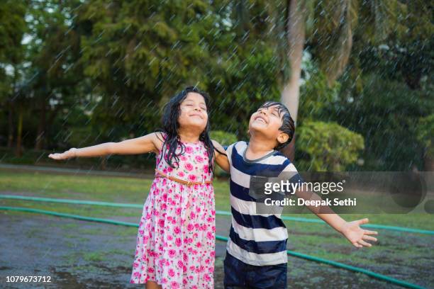 enjoying rain - stock image - brother sister stock pictures, royalty-free photos & images