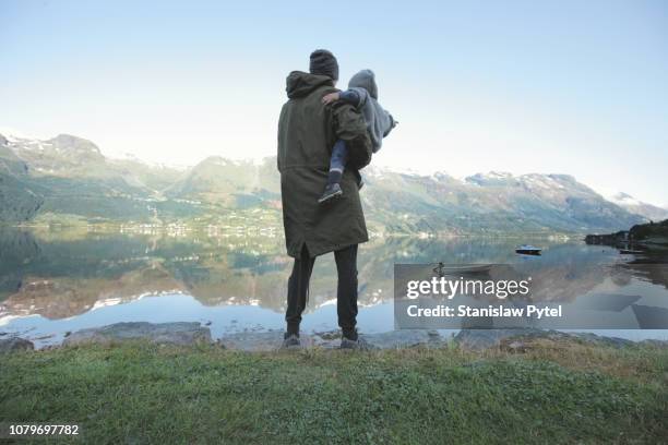 father with daughter standing on lakes edge - huva bildbanksfoton och bilder