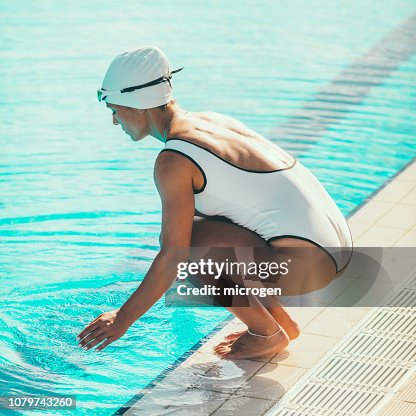 Pool Crounching Side View Of Female Swimmer Crouching At Poolside High-Res Stock Photo ...