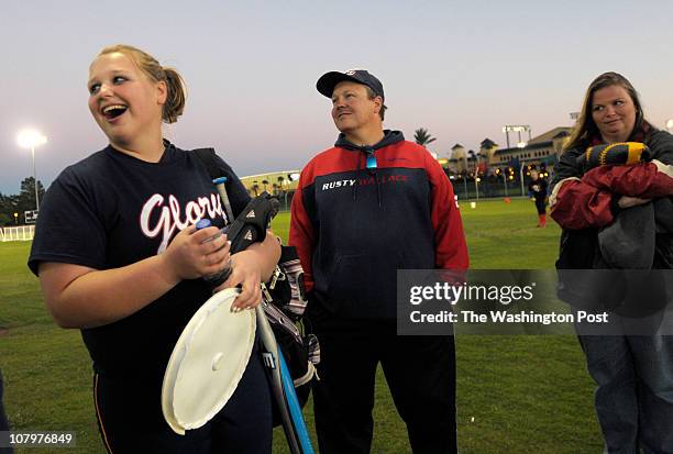 Ashley Runion, left, shares a laugh with her father, Sonny Runion, center, and mother, Shelly Runion, before playing in a showcase softball game in...