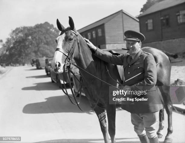 The Earl of Carnarvon, adjutant of a cavalry training regiment of the British Army in Maidstone, Kent, during World War II, with his charger, 1st...