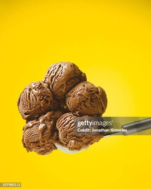 chocolate ice cream against yellow background - schokoladeneis stock-fotos und bilder