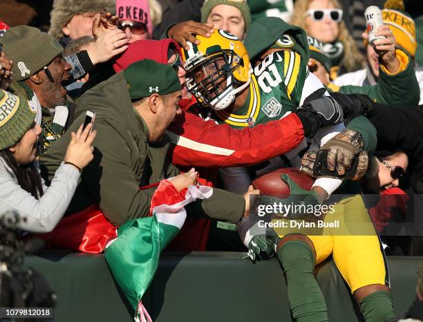 Bashaud Breeland of the Green Bay Packers celebrates with fans after returning an interception for a touchdown during the first half of a game...