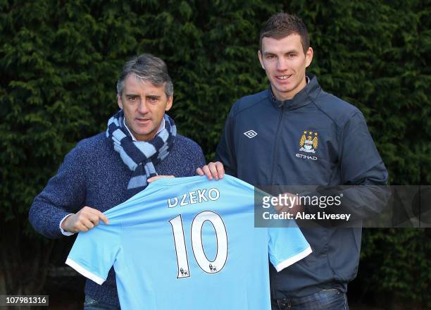 Edin Dzeko the new signing for Manchester City poses with Roberto Mancini the manager of Manchester City during a photocall at the Carrington...
