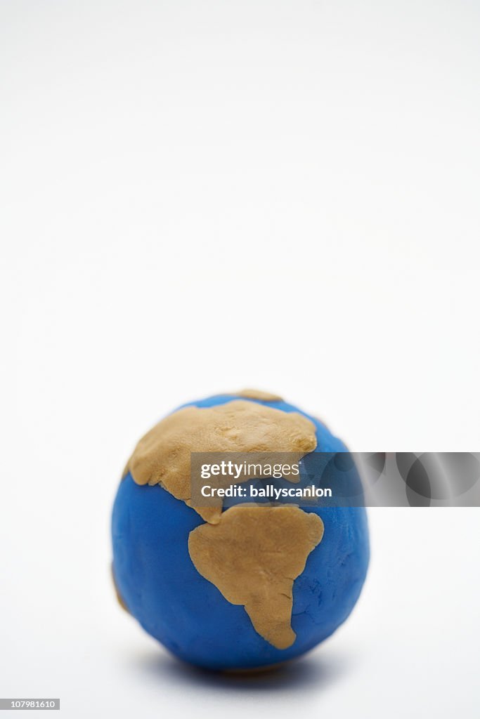 Model of planet earth made on clay on white backgr