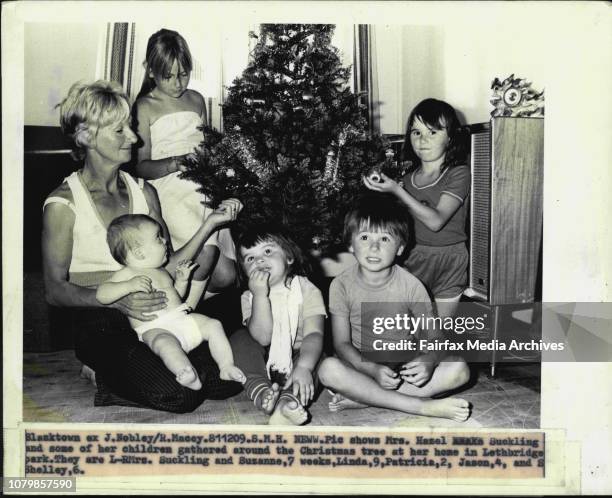 Mrs. Hazel Suckling and some of her children gathered around the Christmas tree at her home in Lethbridge park. They are L- Mrs. Suckling and...