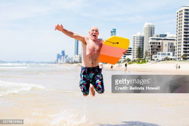 active australian senior enjoying a day on gold coast beach - gold coast australia stockfoto's en -beelden