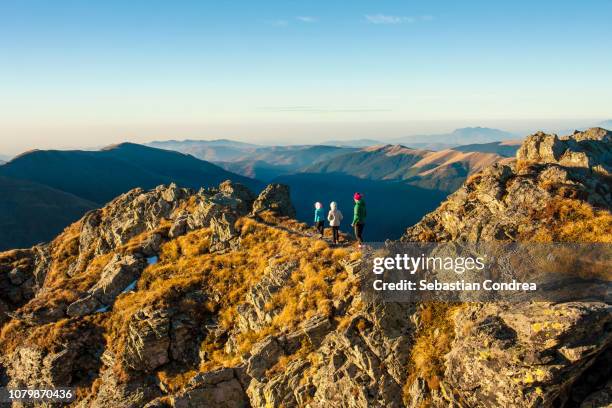 balancing girls on the ridge of the vantarea of buteanu peak on sunrise, fagaras mountains, romania - carpathian mountain range stock-fotos und bilder