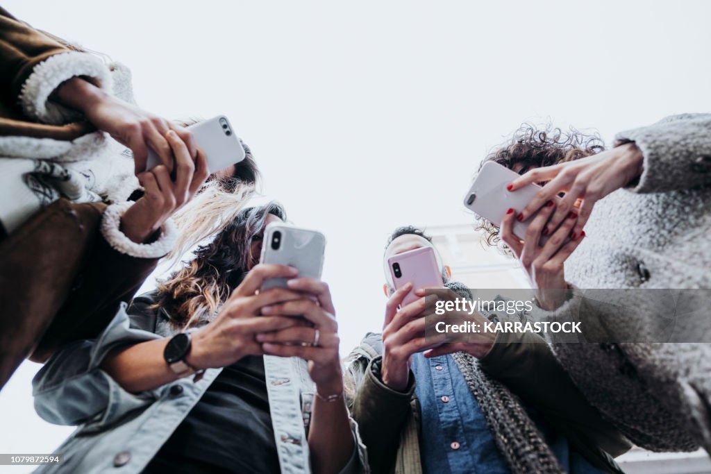 Group of friends in the street with smartphone