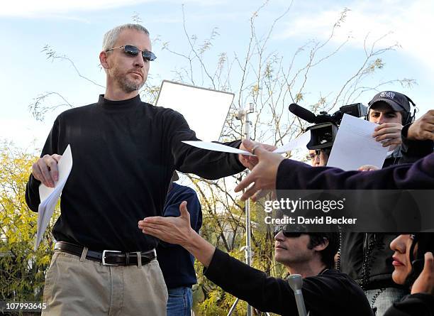 An unidentified man passes out a written statement from the family of Jared Lee Loughner outside of his home on January 11, 2011 in Tucson, Arizona....